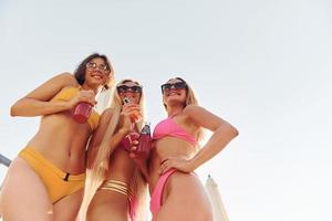 visie van onderstaand. Dames in zwemkleding hebben pret buitenshuis samen Bij zomertijd foto