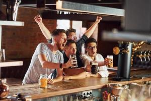 mensen in gewoontjes kleren zittend in de kroeg en drinken bier foto