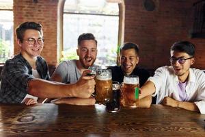 drinken bier. mensen in gewoontjes kleren zittend in de kroeg foto