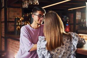 Mens en vrouw. mensen in gewoontjes kleren zittend in de kroeg foto