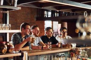 mensen in gewoontjes kleren zittend in de kroeg en drinken bier foto