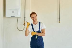 baan is gedaan. jong Mens werken in uniform Bij bouw Bij dag foto