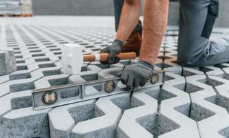 maken van vloer. jong Mens werken in uniform Bij bouw Bij dag foto