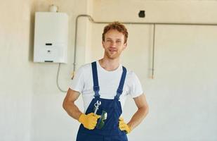 baan is gedaan. jong Mens werken in uniform Bij bouw Bij dag foto