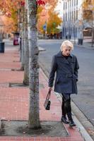 modieus blond vrouw wandelen verkennen de stad. foto