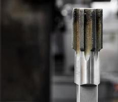 wijnoogst antiek automotive machine winkel hardmetaal staal dieptepunt plug kraan met metaal deponeringen foto