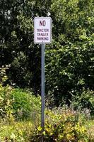Nee trekker aanhangwagen parkeren teken tegen veel struiken foto