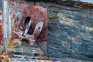 oud roestig anker Aan een verweerd houten boot foto