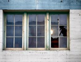 oud gebouw venster met ruiten en gebroken glas foto