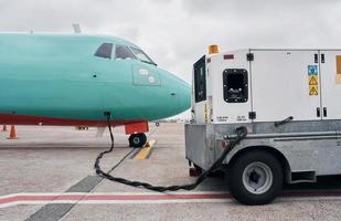 voertuig in de buurt. turboprop vliegtuig geparkeerd Aan de landingsbaan Bij dag foto