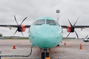 retro stijl. turboprop vliegtuig geparkeerd Aan de landingsbaan Bij dag foto