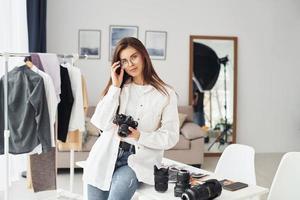 vrouw fotograaf in gewoontjes kleren is werken binnenshuis Bij dag foto