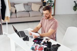 fotograaf in gewoontjes kleren is werken binnenshuis Bij dag foto