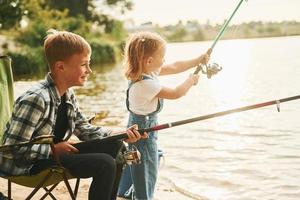 medium formaat meer. jongen met zijn zus in Aan vissen buitenshuis Bij zomertijd samen foto