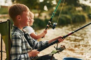 medium formaat meer. jongen met zijn zus in Aan vissen buitenshuis Bij zomertijd samen foto