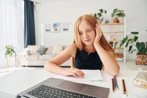 online school. vrouw tiener met blond haar- is Bij huis Bij dag foto