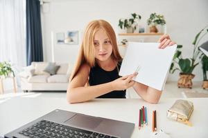 online school. vrouw tiener met blond haar- is Bij huis Bij dag foto