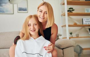 positief emoties. vrouw tiener met haar moeder is Bij huis Bij dag foto