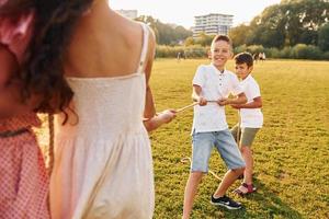 hebben plezier. groep van gelukkig kinderen is buitenshuis Aan de sportief veld- Bij dag foto