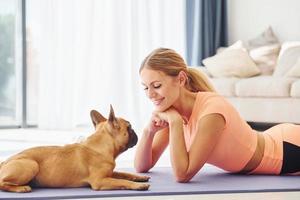 houdende naar beneden Aan de mat. vrouw met mopshond hond is Bij huis Bij dag foto