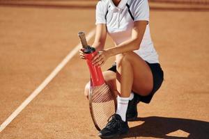 met fles van water. vrouw tennis speler is Aan de rechtbank Bij dag foto