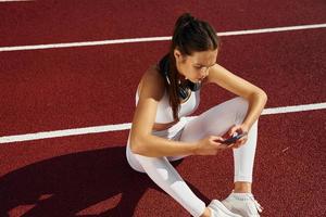 moe, nemen pauze. jong vrouw in sportief kleren is oefenen buitenshuis foto