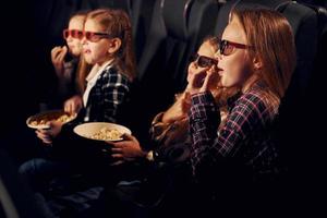 in 3d bril. groep van kinderen zittend in bioscoop en aan het kijken film samen foto