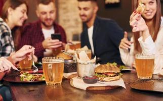 weekend vrije tijd. groep van jong vrienden zittend samen in bar met bier foto