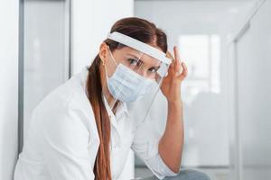 hebben hoofdpijn. professioneel medisch in wit jas is in de kliniek foto