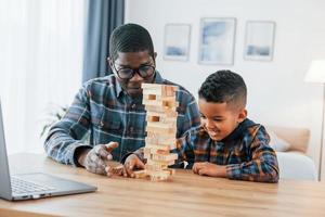 spelen samen. Afrikaanse Amerikaans vader met zijn jong zoon Bij huis foto