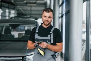 afvegen handen. Mens in uniform is werken in de autosalon Bij dag foto