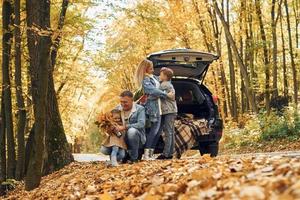 auto is achter. gelukkig familie is in de park Bij herfst tijd samen foto