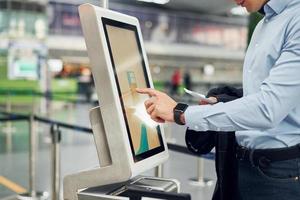 jong mannetje passagier in formeel kleren is in de luchthaven foto