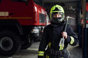 mannetje brandweerman in beschermend uniform staand in de buurt vrachtauto foto