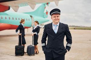 vliegtuig bemanning in werk uniform is samen buitenshuis in de buurt vlak foto