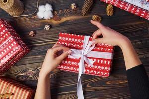 meisje maken geschenk doos. top visie van Kerstmis feestelijk kader met nieuw jaar decoraties foto