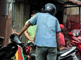 pekanbaru, Indonesië - december 04, 2022 een aantal van mensen wie zijn Bij een motorfiets reparatie winkel naar reparatie hun motoren foto