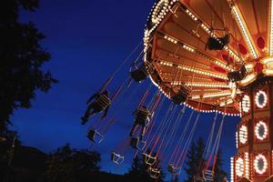 carrousel draaimolen in amusement park Bij een nacht stad foto