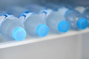 flessen met verkoudheid water in koelkast, detailopname foto