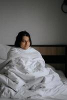 lui vrouw verpakt in zacht deken zittend in knus bed foto