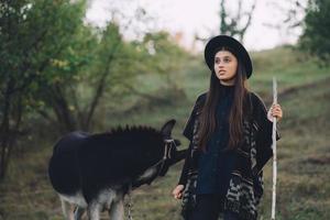 gelukkig jong vrouw op reis met ezel in natuur foto