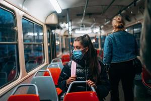 jong vrouw met masker op reis in de openbaar vervoer. foto