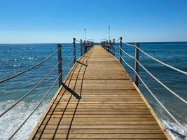 een houten lang ponton, een pier met een touw traliewerk Aan de zee Aan de strand Aan vakantie in een paradijs warm oostelijk tropisch land toevlucht foto