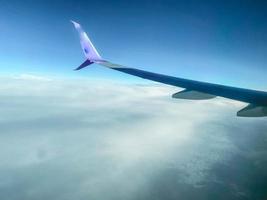 vliegtuig staart. reizen door de lucht naar een ander land. de vlak stijgt in de lucht en vliegt in cumulus wolken foto