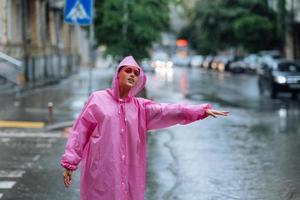 jong meisje proberen naar hou op een taxi. vrouw roeping een taxi Aan een regenachtig dag. foto