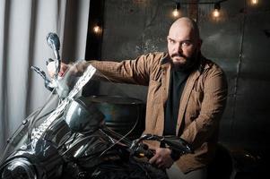 portret van een Mens in een overhemd met een baard Aan een motorfiets foto