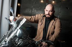 portret van een Mens in een overhemd met een baard Aan een motorfiets foto