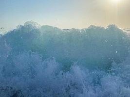 golven, spatten van water Aan de strand Bij de zee Aan vakantie in een toerist warm oostelijk tropisch land zuidelijk paradijs toevlucht Aan vakantie. de achtergrond foto