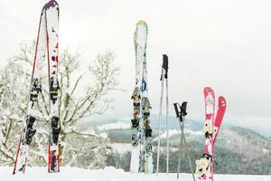 afbeelding van drie paren van skis van skiërs familie Aan de stoel optillen foto