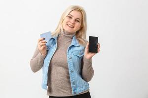 portret van een gelukkig vrouw buying online met een slim telefoon geïsoleerd wit achtergrond foto